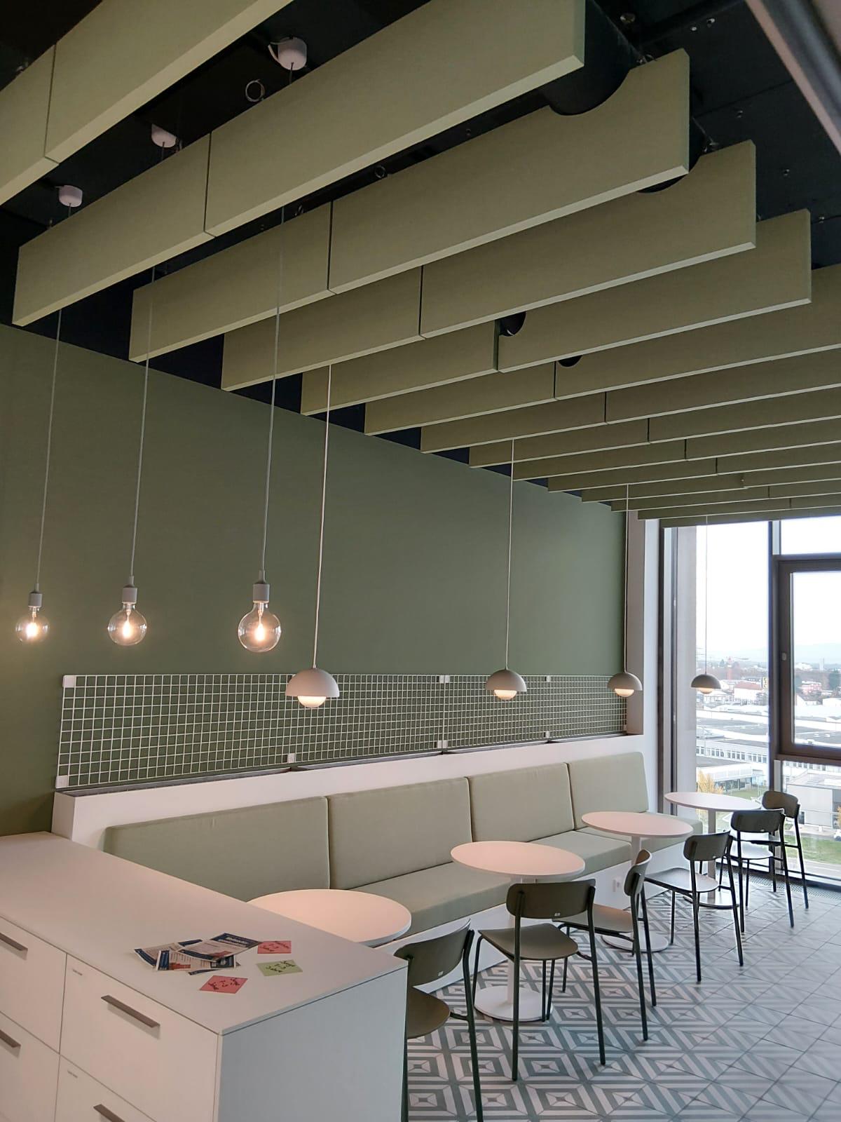 Grüne Akustikbaffeln über einem Café-Bereich im Projekt Edeka in Offenburg